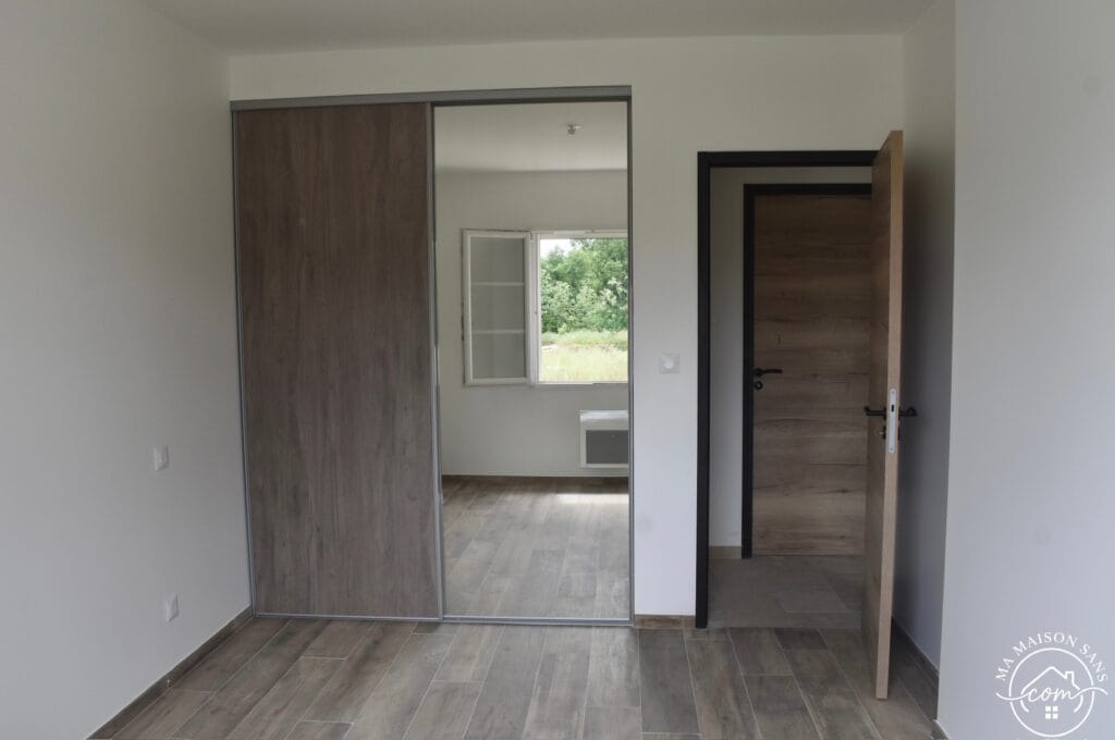 chambre ou l'on voit le placard encastré avec porte coulissantes.